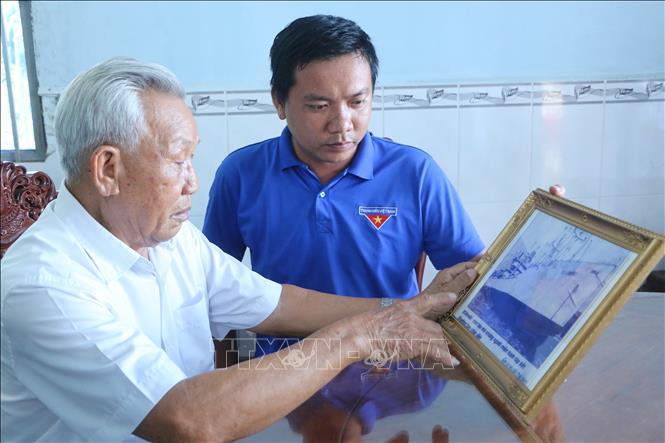 Trong ảnh: Ông Đặng Thanh Dân, bên ảnh kỷ niệm con tàu Kilinski-chuyến tàu tập kết cuối cùng của miền Nam. Ảnh: Thanh Bình- TTXVN