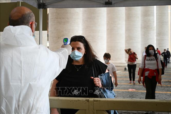 Trong ảnh: Du khách được kiểm tra thân nhiệt trước khi vào Nhà thờ Thánh Peter tại Tòa thánh Vatican ngày 18/5/2020. Ảnh: AFP/TTXVN