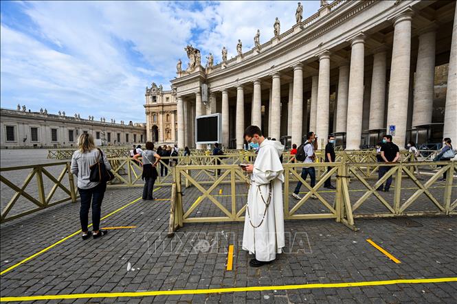 Trong ảnh: Du khách xếp hàng chờ kiểm tra thân nhiệt trước khi vào Nhà thờ Thánh Peter tại Tòa thánh Vatican ngày 18/5/2020. Ảnh: AFP/TTXVN