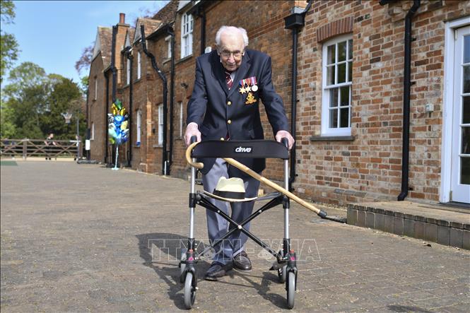 Trong ảnh: Đại tá Tom Moore đi bộ 100 vòng trong khu vườn ở Marston Moretaine, phía bắc London ngày 16/4/2020, nhằm gây quỹ hỗ trợ đội ngũ y tế Anh đối phó dịch COVID-19. Ảnh: AFP/ TTXVN