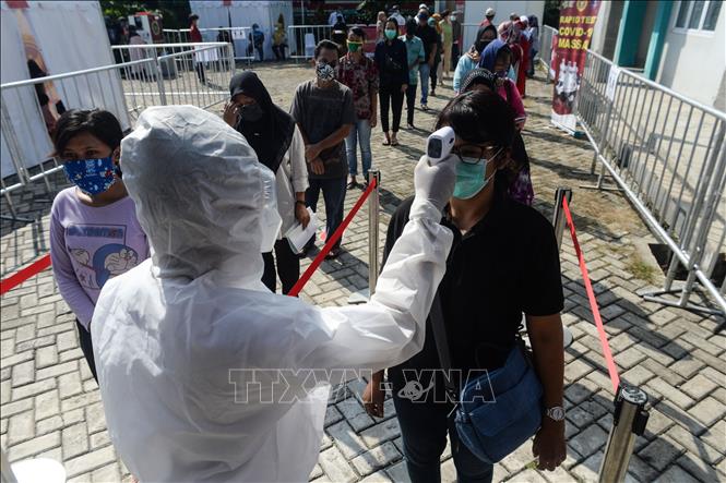 Trong ảnh: Kiểm tra thân nhiệt nhằm ngăn chặn sự lây lan của dịch COVID-19 tại Nam Tangerang, Indonesia, ngày 14/5/2020. Ảnh: THX/TTXVN