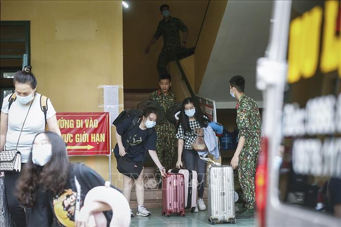 Trong ảnh: Các chiến sĩ giúp công dân vận chuyển hành lý rời khu vực cách ly để trở về nhà. Ảnh: Trọng Đạt - TTXVN