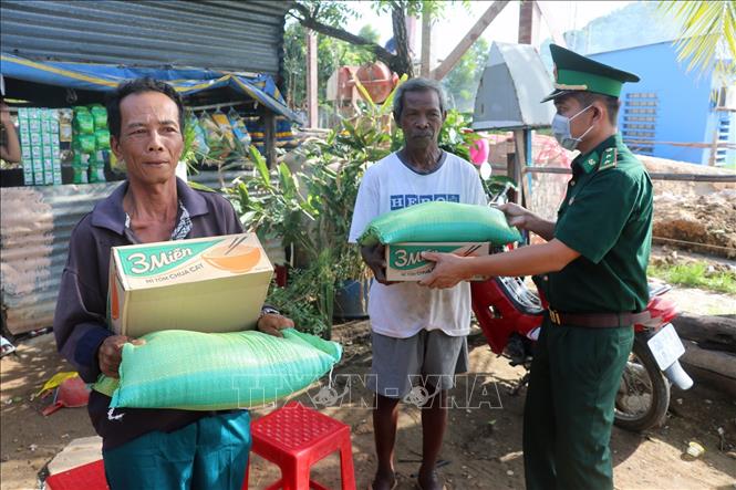 Trong ảnh: Cán bộ Đồn Biên phòng cửa khẩu Quốc tế Hà Tiên hỗ trợ gạo, mì gói cho đồng bào dân tộc Khmer nghèo, khó khăn ở phường Mỹ Đức, thành phố Hà Tiên (Kiên Giang). Lê Huy Hải - TTXVN