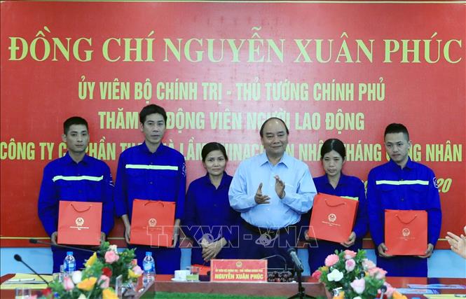 Photo: PM Xuan Phuc  presents 200 gift packages to disadvantaged workers of the Ha Lam company. VNA Photo: Thống Nhất