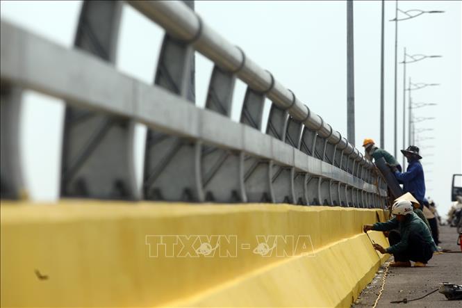 Trong ảnh: Các công nhân đang hoàn thiện nốt những công đoạn cuối cùng trước ngày thông xe. Ảnh: Huy Hùng - TTXVN