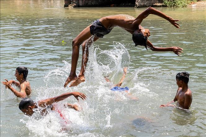 Trong ảnh: Trẻ em tắm sông tránh nóng tại khu vực ngoại ô Amritsar, Ấn Độ ngày 24/5/2020. Ảnh: AFP/TTXVN