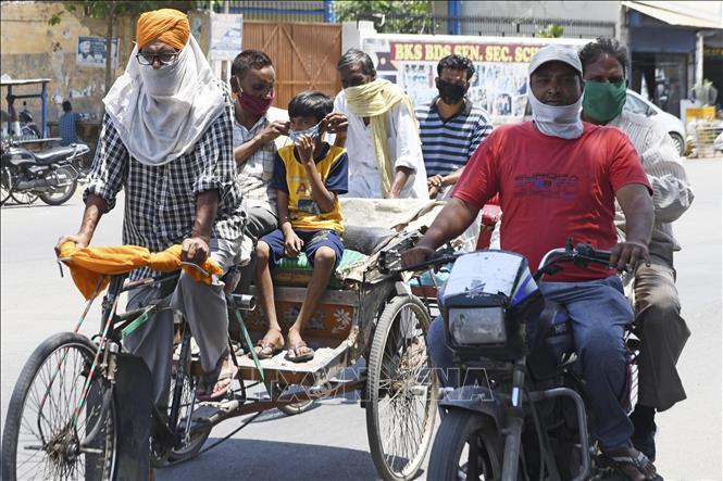 Trong ảnh: Người dân di chuyển trên đường phố dưới trời nắng nóng tại Amritsar, Ấn Độ ngày 24/5/2020. Ảnh: AFP/TTXVN