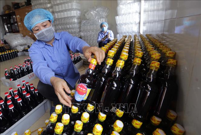 Trong ảnh: Dán mác sản phẩm nước mắm Ninh Cơ tại Công ty. Ảnh: Trần Việt - TTXVN