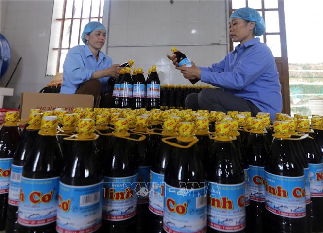 Trong ảnh: Dán mác sản phẩm nước mắm Ninh Cơ tại Công ty. Ảnh: Trần Việt - TTXVN