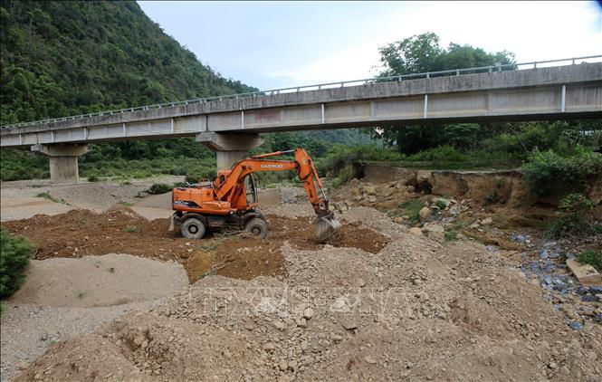 Trong ảnh: Thi công hạng mục nạo vét cuội sỏi bồi lấp lòng sông kết hợp đắp áp trúc dọc bờ sông khu vực mố trụ chân cầu Sê Băng Hiêng. Ảnh: Hồ Cầu-TTXVN