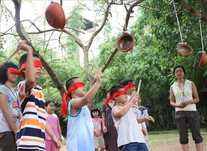 Trong ảnh: Thiếu nhi Hà Nội chơi trò “bịt mắt đập niêu” trong chương trình “Kết nối bè bạn” tại Bảo tàng Dân tộc học Việt Nam nhân dịp Tết thiếu nhi 1/6/2010. Ảnh: Hoàng Mạnh Hùng- TTXVN