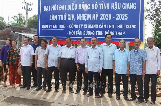 Trong ảnh: Lãnh đạo tỉnh Hậu Giang, huyện Vị Thủy, huyện Phụng Hiệp và người dân địa phương chụp ảnh lưu niệm. Ảnh: Hồng Thái - TTXVN