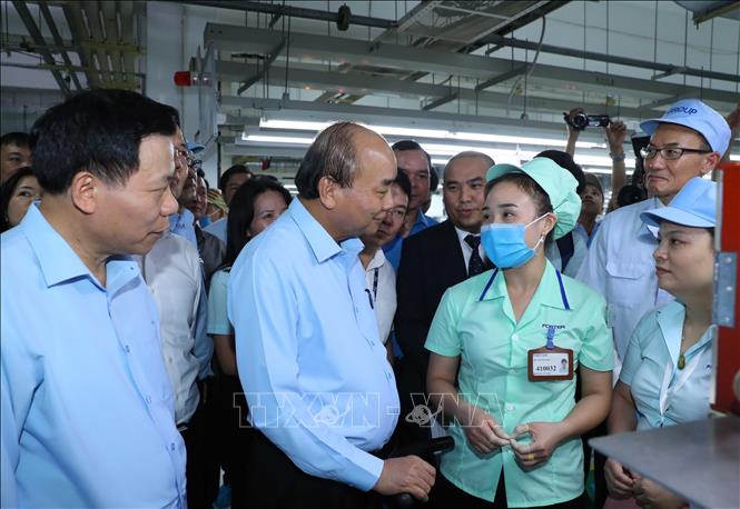 Trong ảnh: Thủ tướng Nguyễn Xuân Phúc trò chuyện với công nhân công ty.  Ảnh: Thống Nhất – TTXVN
