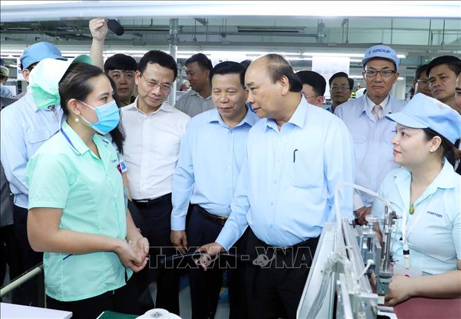 Trong ảnh: Thủ tướng Nguyễn Xuân Phúc nói chuyện với công nhân Công ty TNHH Điện tử Foster (Việt Nam).  Ảnh: Thống Nhất – TTXVN