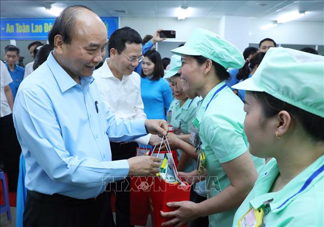 Trong ảnh: Thủ tướng Nguyễn Xuân Phúc tặng quà cho công nhân Công ty TNHH Điện tử Foster (Việt Nam).  Ảnh: Thống Nhất – TTXVN
