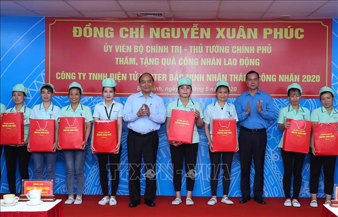 Trong ảnh: Thủ tướng Nguyễn Xuân Phúc tặng quà cho công nhân Công ty TNHH Điện tử Foster (Việt Nam).  Ảnh: Thống Nhất – TTXVN
