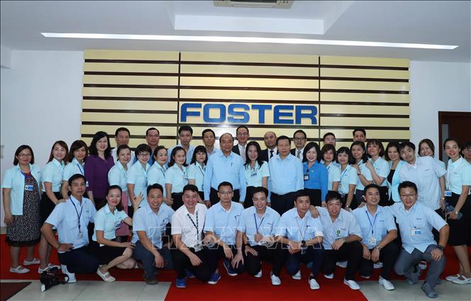 Trong ảnh: Thủ tướng Nguyễn Xuân Phúc với công nhân Công ty TNHH Điện tử Foster (Việt Nam).  Ảnh: Thống Nhất – TTXVN
