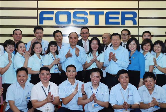 Trong ảnh: Thủ tướng Nguyễn Xuân Phúc với công nhân Công ty TNHH điện tử Foster (Việt Nam).  Ảnh: Thống Nhất – TTXVN