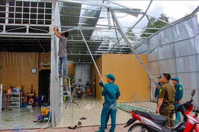 Trong ảnh: Lực lượng chức năng hỗ trợ người dân sửa chữa nhà cửa bị ảnh hưởng do dông lốc ở huyện Thới Lai, thành phố Cần Thơ. Ảnh: TTXVN phát