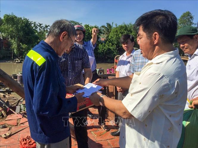 Trong ảnh: Lãnh đạo UBND quận Thốt Nốt (Cần Thơ) trao tiền hỗ trợ người dân bị thiệt hại do dông lốc xảy ra vào chiều 30/5. Ảnh: TTXVN phát