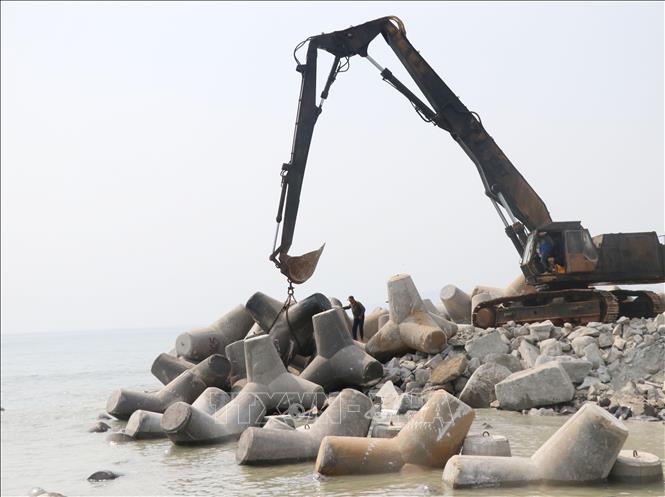 Trong ảnh: Các trụ chắn sóng được thả xuống biển. Ảnh: Phạm Cường - TTXVN
