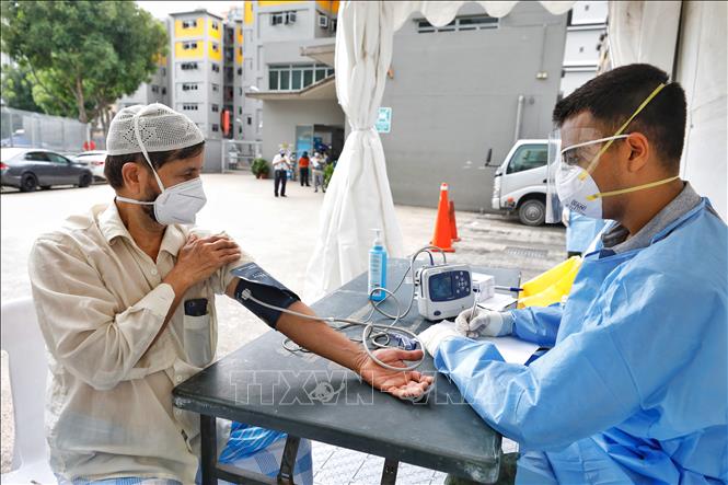 Trong ảnh: Khám sức khỏe cho người lao động nhập cư tại một khu ký túc xá ở Singapore, ngày 8/4/2020. Ảnh: THX/TTXVN