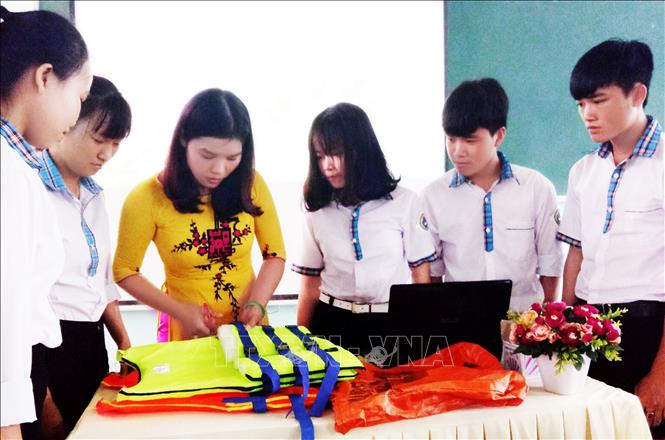 Trong ảnh: Cô giáo Mai Thùy Hân (Quảng Bình) hướng dẫn học sinh làm sản phẩm tái chế từ rác thải thành đồ dùng hữu ích cho cuộc sống. Ảnh: Võ Thị Dung-TTXVN