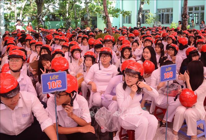 Trong ảnh: Các em học sinh rất vui mừng khi đội mũ bảo hiểm do Công ty Honda Việt Nam trao tặng. Ảnh: Văn Dũng - TTXVN