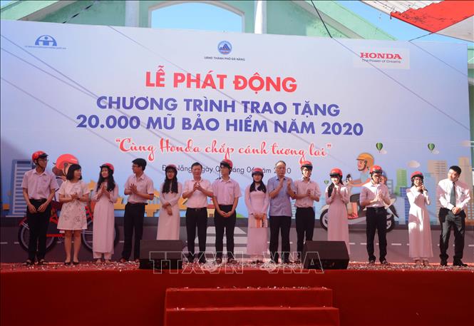 Trong ảnh: Trao tượng trưng 20.000 mũ bảo hiểm năm 2020. Ảnh: Văn Dũng - TTXVN