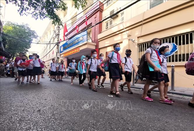 Trong ảnh: Học sinh Trường Tiểu học Thăng Long đi theo hàng đến điểm đón quy định tại phố Ngõ Trạm. Ảnh: Thành Đạt - TTXVN 