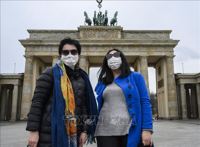 Trong ảnh: Người dân đeo khẩu trang phòng dịch COVID-19 tại Berlin, Đức ngày 20/3/2020. Ảnh: AFP/TTXVN