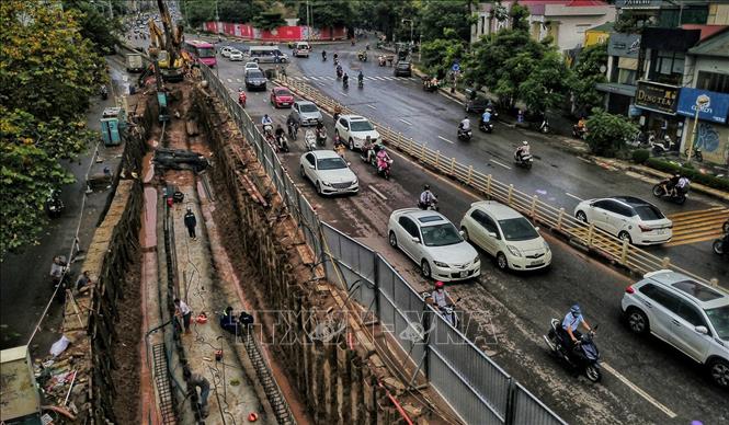 Trong ảnh: Dự án sẽ hạ cao độ đường Âu Cơ để thay thế một phần kết cấu đê đất bằng tường bê tông cốt thép (phía ngoài đê), kết hợp với mở rộng mặt đường đê, cải tạo và chỉnh trang hệ thống đường gom dân sinh, xây dựng tường chắn tại vị trí dải phân cách giữa mặt đường chính để xử lý chênh cao độ giữa hai làn đường. Ảnh: Thành Đạt - TTXVN 