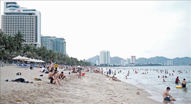 Trong ảnh: Bãi biển Nha Trang (đoạn dọc theo đường Trần Phú) đông đảo người dân và du khách đến tắm trong những ngày cao điểm nắng nóng. Ảnh: Nguyễn Dũng – TTXVN