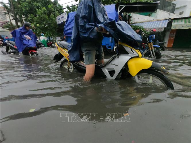 Trong ảnh: Nước ngập hơn nửa bánh xe trên đường Nguyễn Duy Trinh (Quận 2). Ảnh: Hồng Giang-TTXVN.