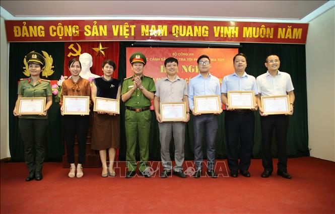 Trong ảnh: Đại tá Nguyễn Văn Viện, Cục trưởng Cục Cảnh sát điều tra tội phạm về ma túy tặng Giấy khen cho các phóng viên, biên tập viên các cơ quan báo chí có thành tích trong tuyên truyền phòng, chống ma túy. Ảnh: TTXVN