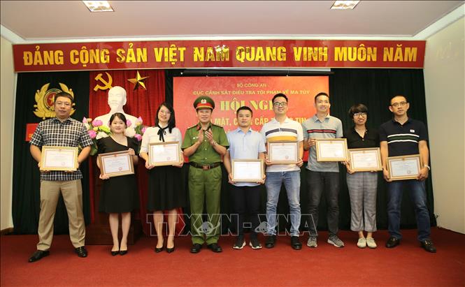 Trong ảnh: Đại tá Nguyễn Văn Viện, Cục trưởng Cục Cảnh sát điều tra tội phạm về ma túy tặng Giấy khen cho các phóng viên, biên tập viên các cơ quan báo chí có thành tích trong tuyên truyền phòng, chống ma túy. Ảnh: Doãn Tấn - TTXVN