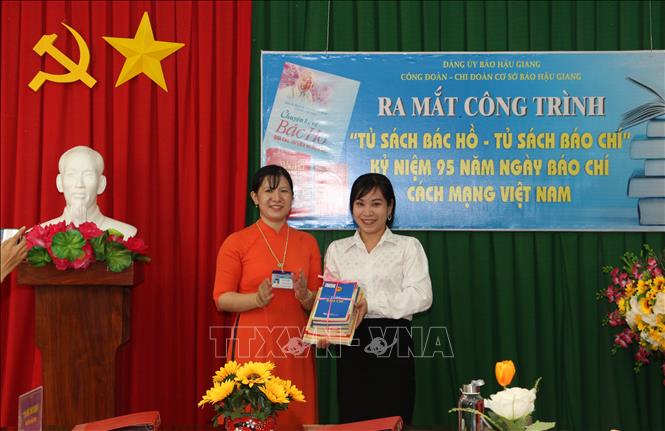 Trong ảnh: Đại diện Thư viện tỉnh Hậu Giang tặng sách cho tủ sách. Ảnh: Hồng Thái - TTXVN