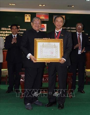 Trong ảnh: Nhà báo Trần Chí Hùng (bên phải) nhận Huân chương Công trạng hạng Nhất của Vương quốc Campuchia. Ảnh: Tư liệu/TTXVN phát  