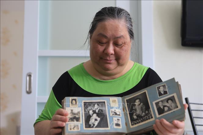 Trong ảnh: Chị Lê Thị Phượng bên cuốn album gia đình cùng những hình ảnh của người cha Lý Phú San. Ảnh: Trần Hiếu - PV TTXVN tại LB Nga
