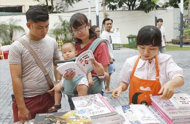Trong ảnh: Các cặp vợ chồng đưa con đi chơi, mua sách trong Ngày của Cha (2017). Ảnh: Doãn Tấn – TTXVN