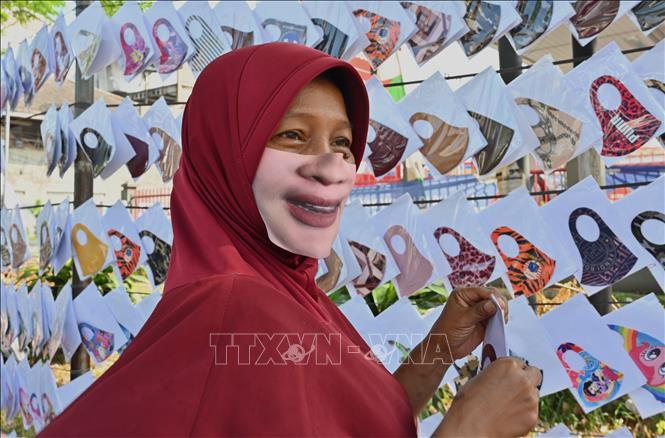 Trong ảnh: Người dân đeo khẩu trang có in hình mặt cười tại Tangerang, Indonesia ngày 2/6/2020. Ảnh: AFP/TTXVN