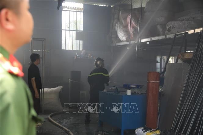 Trong ảnh: Lực lượng chức năng tiến vào bên trong kho hàng để chữa cháy. Ảnh: Thành Đạt - TTXVN