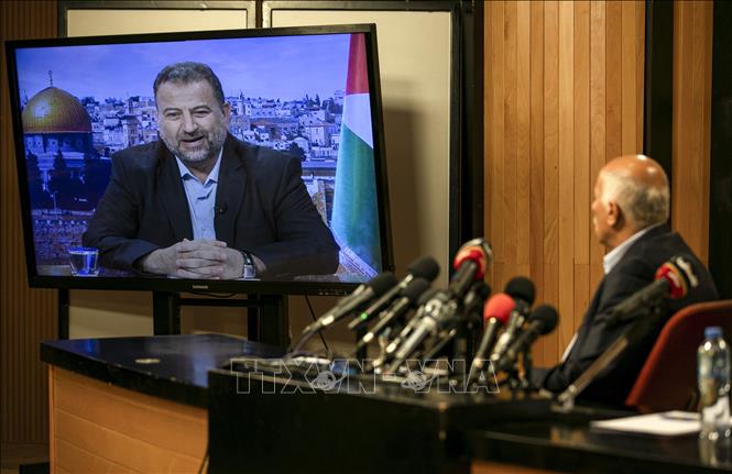 Trong ảnh: Quan chức cấp cao phong trào Fatah, Jibril Rajub (phải) tại thành phố Ramallah trong cuộc họp trực tuyến với quan chức phái Hamas, ông Saleh al-Arouri (trên màn hình) ở Beirut (Lebanon) ngày 2/7/2020. Ảnh: AFP/TTXVN