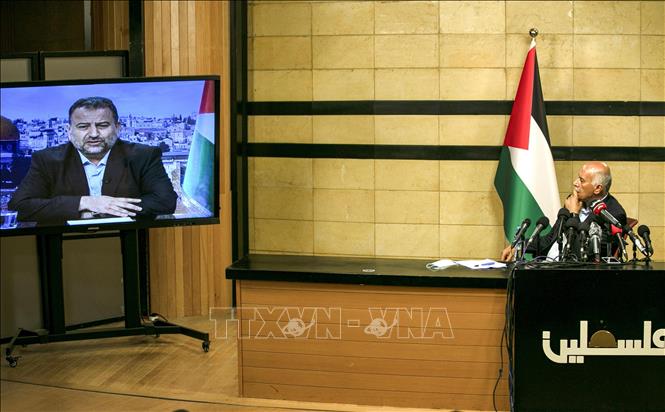 Trong ảnh: Quan chức cấp cao phong trào Fatah, Jibril Rajub (phải) tại thành phố Ramallah trong cuộc họp trực tuyến với quan chức phái Hamas, ông Saleh al-Arouri (trên màn hình) ở Beirut (Lebanon) ngày 2/7/2020. Ảnh: AFP/TTXVN