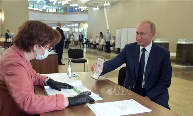 Trong ảnh: Tổng thống Nga Vladimir Putin (phải) làm thủ tục tại điểm bỏ phiếu trưng cầu dân ý về sửa đổi Hiến pháp ở Moskva ngày 1/7/2020. Ảnh: AFP/TTXVN