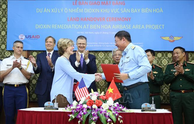Trong ảnh: Thiếu tướng Bùi Anh Chung, Phó Tư lệnh Quân chủng Phòng không- Không quân và bà Bonnie Glick, Phó Tổng Giám đốc toàn cầu Cơ quan Phát triển quốc tế Hoa Kỳ ký kết bàn giao mặt bằng Dự án xử lý ô nhiễm dioxin khu vực sân bay Biên Hòa. Ảnh: Dương Giang - TTXVN