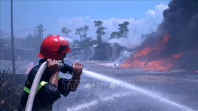 Trong ảnh: Cảnh sát phòng cháy chữa cháy phun nước ngăn không cho lửa lan sang khu vực xung quanh. Ảnh: Nguyễn Nam-TTXVN