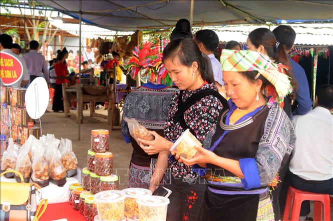 Trong ảnh: Khách tham quan các gian hàng giới thiệu sản phẩm của huyện Mường La tại buổi khai trương mô hình du lịch cộng đồng tại xã Ngọc Chiến. Ảnh: Quang Quyết-TTXVN