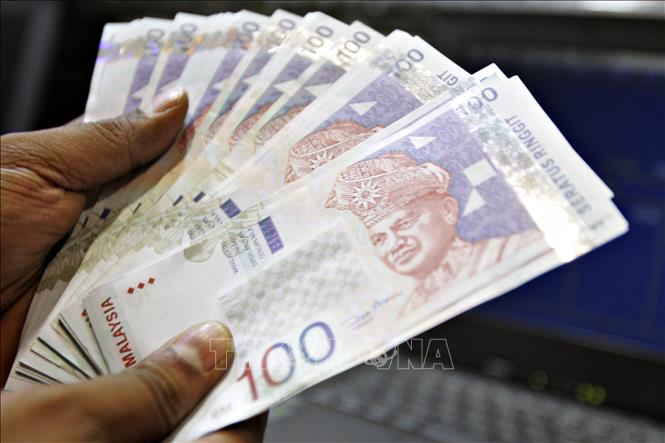 Trong ảnh: Kiểm tiền ringgit của Malaysia tại một quầy giao dịch tiền tệ ở Kuala Lumpur, Malaysia. Ảnh: AFP/ TTXVN