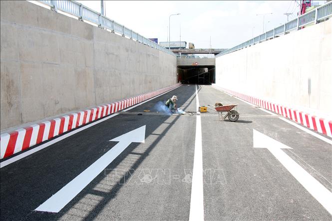 Trong ảnh: Công nhân đang hoàn thiện những công việc cuối cùng để Nhánh N2 thông xe vào sáng 15/7. Ảnh: Tiến Lực - TTXVN